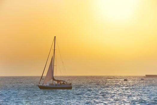 Sail boat against sea sunset. Colorful marine landscape.