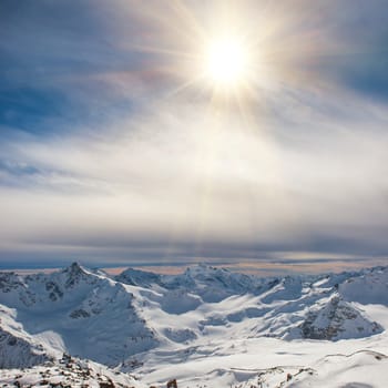 Snowy blue mountains in clouds. Winter ski resort