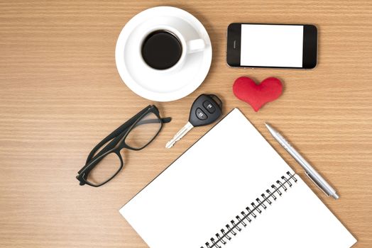 office desk : coffee and phone with car key,eyeglasses,notepad,heart on wood background