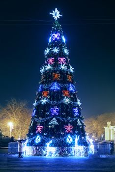 Blured blue christmas tree with colorful magic lights