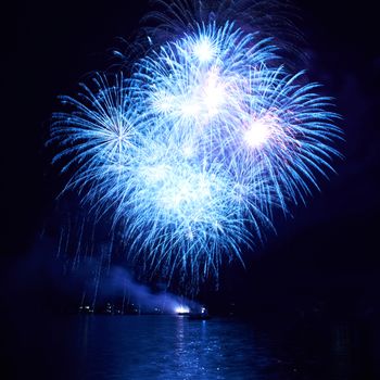 Blue colorful fireworks on the black sky background