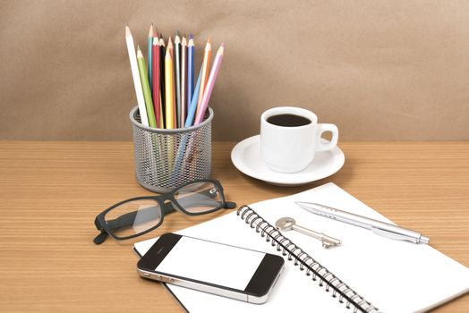 office desk : coffee and phone with key,eyeglasses,notepad,pencil box
