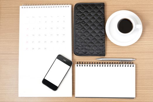 desktop : coffee with phone,notepad,wallet,calendar on wood background