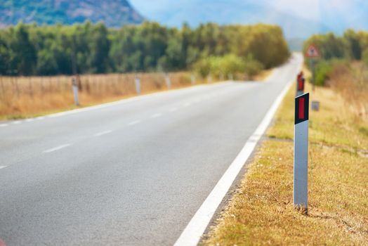 Road pole on highway. Travel landscape with mountains on horizon