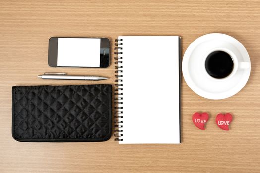 working table : coffee with phone,notepad,wallet and red heart on wood background