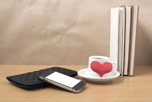 working table : coffee with phone,stack of book,wallet and heart on wood background