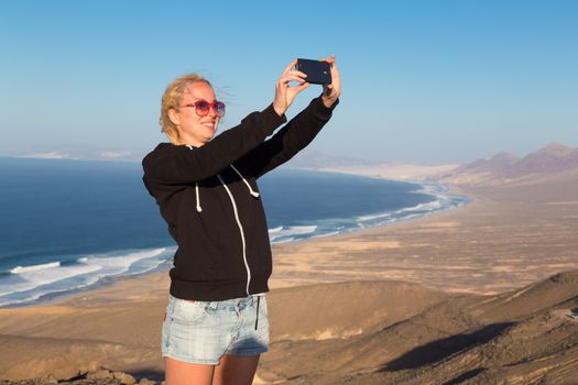 Lady taking holiday selfie on El Cofete beach, Fuerteventura, Canary Islands, Spain.