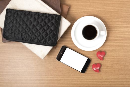 office desk : coffee with phone,stack of book,wallet on wood background