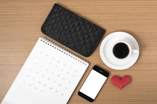 office desk : coffee with phone,wallet,calendar,heart on wood background