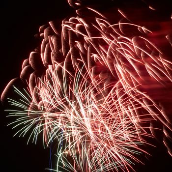 Red colorful holiday fireworks on the black sky background.