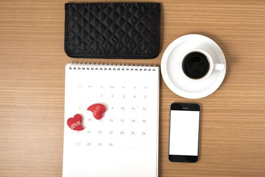 office desk : coffee with phone,calendar,wallet,heart on wood background