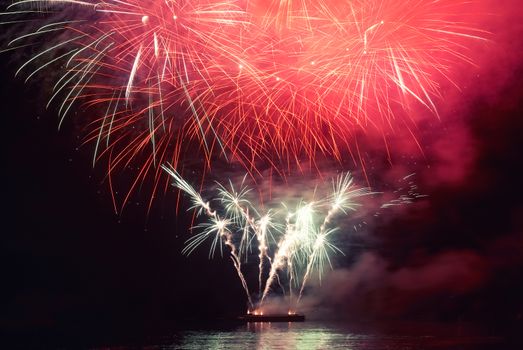 Red colorful holiday fireworks on the black sky background.