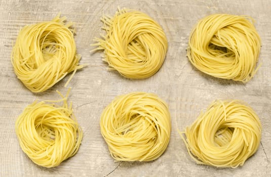 A few skeins of spaghetti lying on old wooden background