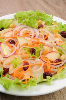 Dietary salad with apples, daikon, carrots, lettuce ,  cranberries and peanuts