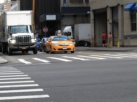 A NYC taxi cab at a crosswalk.