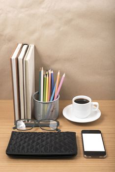 office desk : coffee with phone,stack of book,eyeglasses,wallet,color pencil box on wood background