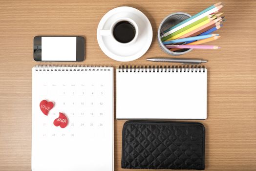 office desk : coffee with phone,wallet,calendar,heart,color pencil box,notepad on wood background