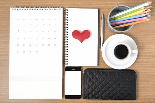 office desk : coffee with phone,wallet,calendar,heart,color pencil box,notepad,heart on wood background