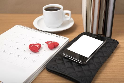 office desk : coffee with phone,wallet,calendar,heart,stack of book on wood background