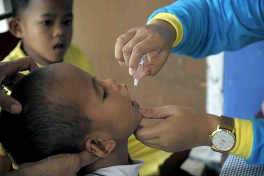 INDONESIA, Jakarta: A child receives Polio immunization in Ciracas, East Jakarta on March 10, 2016 during  National Polio Immunization Week. Indonesian Health Minister Nila Moeloek announced on March 8, 2016 plans to vaccinate 23.7 million babies — from birth to 59 months of age — to keep the world on track toward being polio-free by 2020.