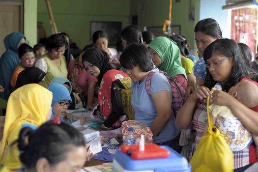 INDONESIA, Jakarta: Mothers queue for their children to receive Polio immunization in Ciracas, East Jakarta on March 10, 2016 during  National Polio Immunization Week. Indonesian Health Minister Nila Moeloek announced on March 8, 2016 plans to vaccinate 23.7 million babies — from birth to 59 months of age — to keep the world on track toward being polio-free by 2020.