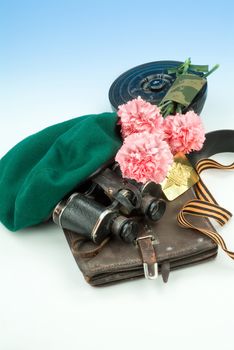 Flowers and army equipment on a studio background
