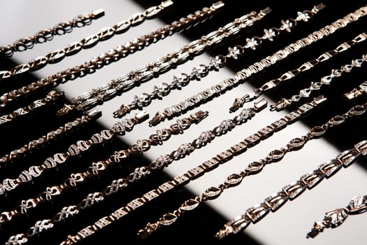 Golden bracelets on a black glass background with white highlight