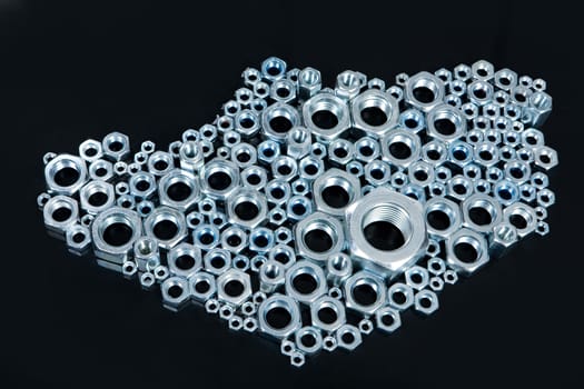 Metal screws on a black glass background