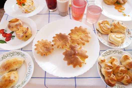 Table lined with plates of soups, cereals and pastries