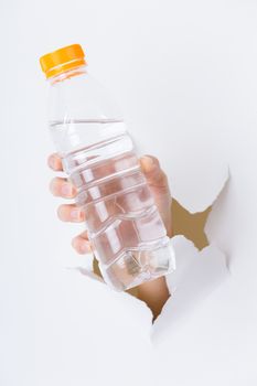 Woman hand with bottle of water through a hole in paper