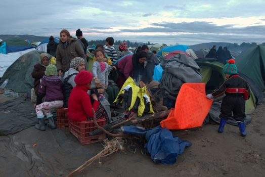 GREECE, Idomeni: Migrants get warm by a bonfire at the Greek-Macedonian border near the Greek village of Idomeni on March 10, 2016, where thousands of refugees and migrants are trapped by the Balkan border blockade. The German and Greek leaders blasted Balkan countries for shutting their borders to migrants ahead of an EU ministers meeting on March 10. Greek authorities said there were 41,973 asylum seekers in the country, including some 12,000 stuck at Idomeni on the closed Macedonian border.