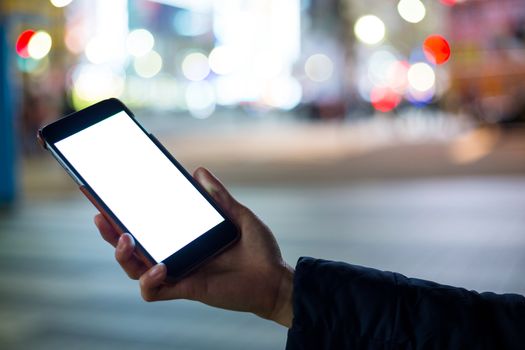 Woman hand holding cellphone at city night