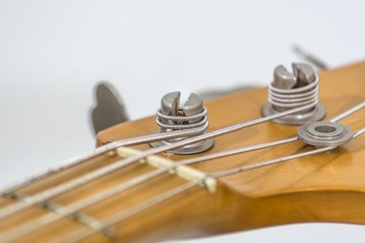 the head of an electric bass with details of the sprocket, the string guide, 