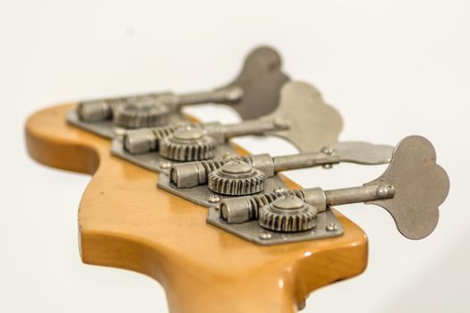 Rear view of a electric bass head with gears, screws and tuners