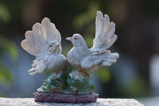 Doves watching over a gravestone. Cemetery figurine. Aged marble