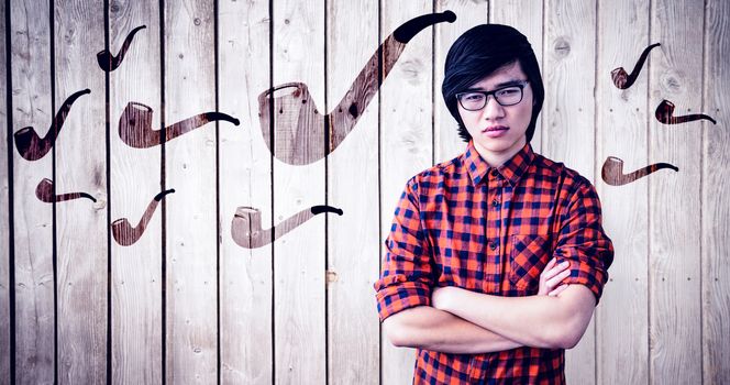 Serious hipster with crossed arms against wooden planks
