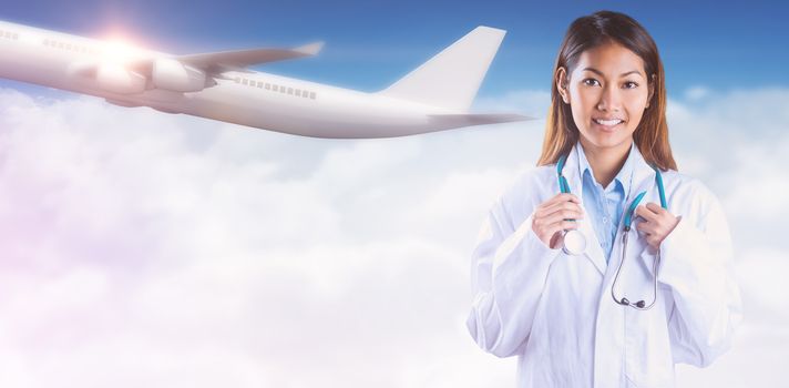 Asian doctor holding stethoscope against bright blue sky over clouds