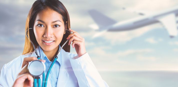 Asian doctor holding her stethoscope against bridge over water and blue sky