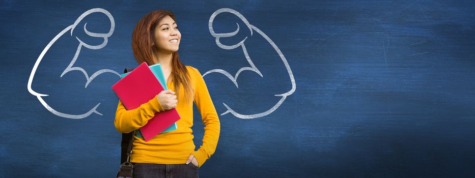 Female college student with books in park against blue chalkboard