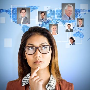 Thoughtful businesswoman with eyeglasses  against background with hexagons and world map