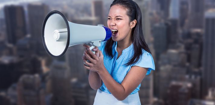 Businesswoman shouting into a megaphone against view of cityscape