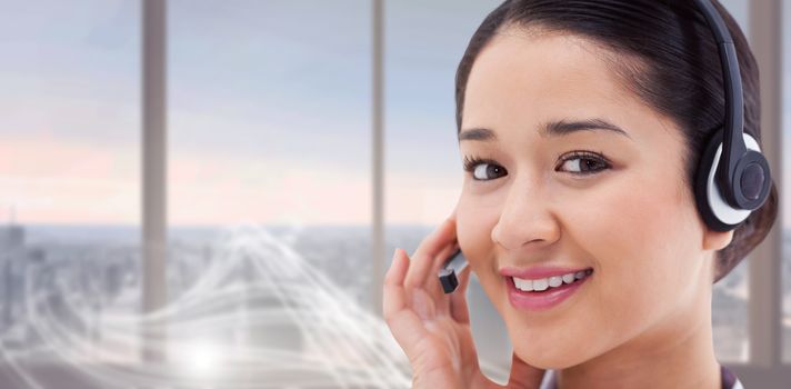 Close up of a smiling operator posing with a headset against abstract white line design in room