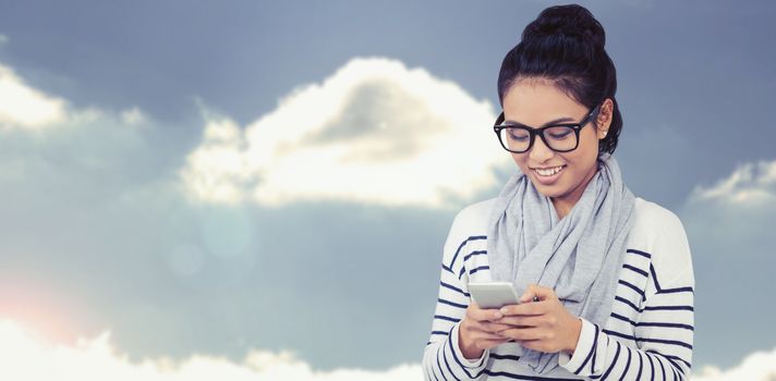 Smiling Asian woman using smartphone against beautiful blue cloudy sky