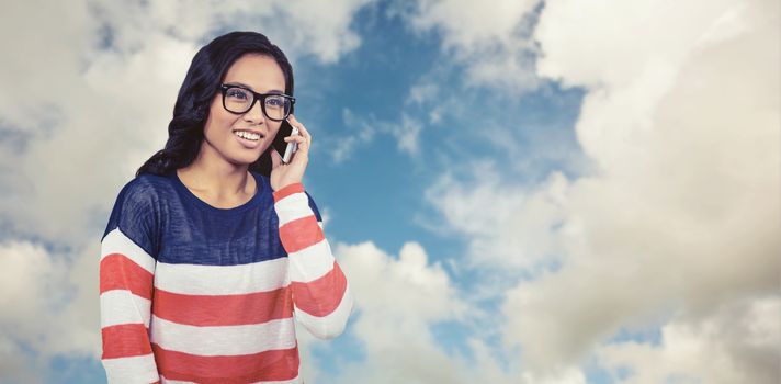 Asian woman on a phone call against blue sky with white clouds