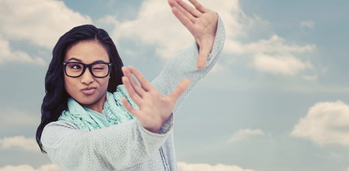 Asian woman making square with hands against beautiful blue cloudy sky