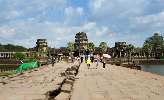 Siem Reap, Cambodia - December 2, 2015: People visit ruined towers on the west of the outer enclosure at Angkor Wat in Siem Reap, Cambodia. The temple has become a symbol of Cambodia