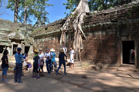 Siem Reap, Cambodia - December 3, 2015: Tourists visit Ta Prohm temple at Angkor, Siem Reap Province, Cambodia. It is one of the most visited complexes in Cambodia’s Angkor region.