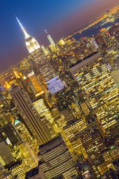 New York City. Manhattan downtown skyline with illuminated Empire State Building and skyscrapers at dusk.