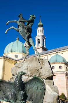 Detail of the Fountain of the Faun with the Cathedral of St. Matthew in the background. Square Carli, Asiago, Italy.