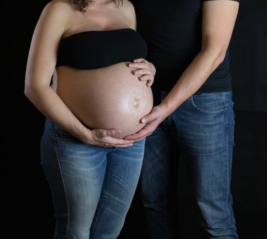 The sweet expectation of a pregnant on dark background.